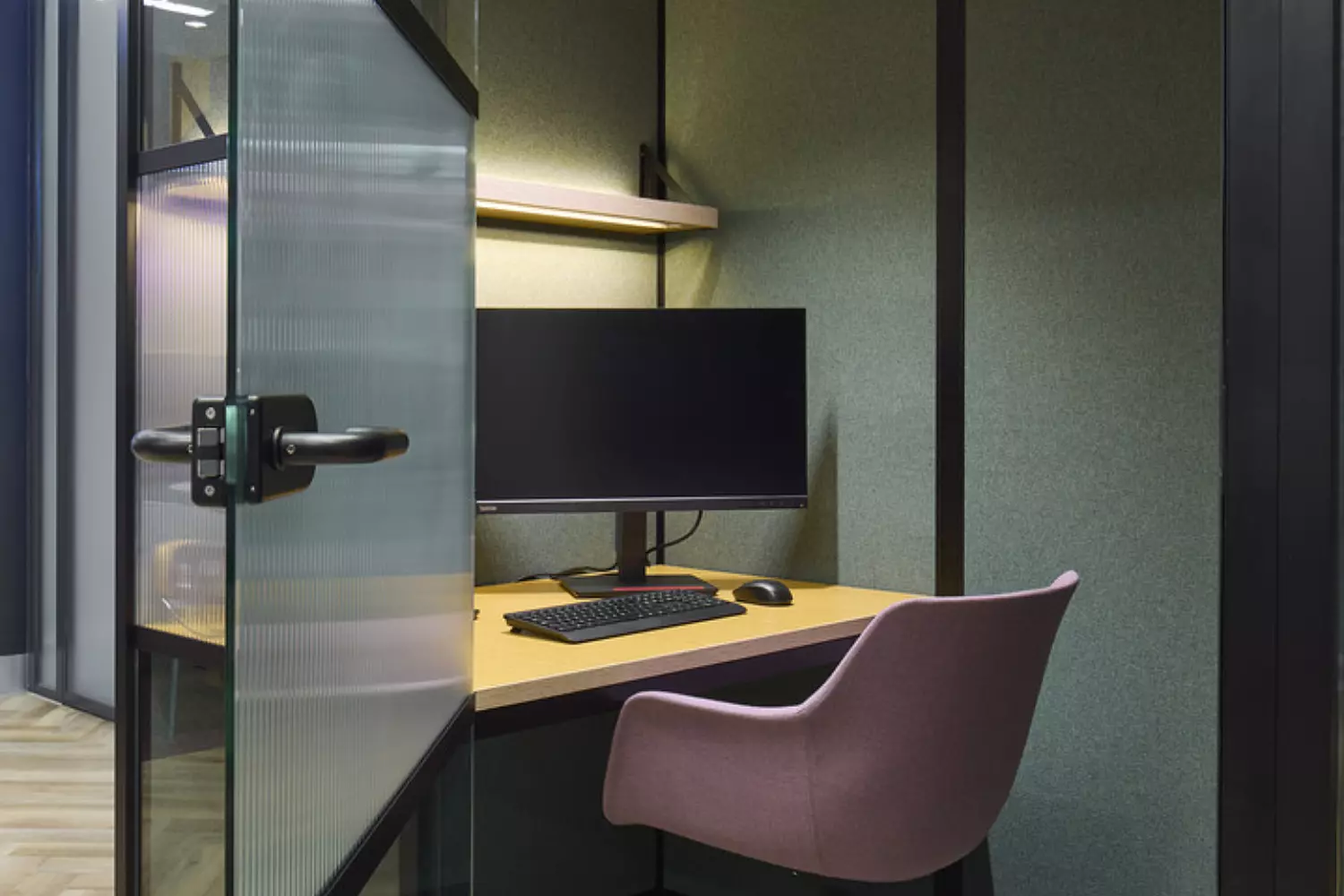 glass booth with desk chair and screen