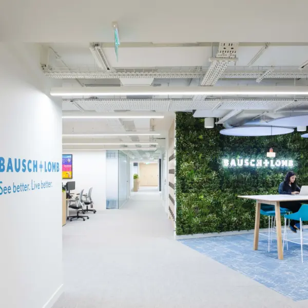 Modern office fit out featuring biophilic office design with a living green wall, open plan workspace, branded reception area and contemporary breakout seating