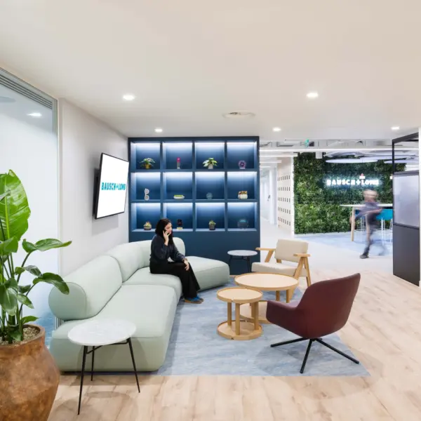 Lounge area at Bausch + Lomb, with a long green sofa and two chairs