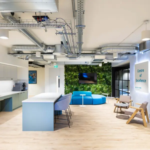 Modern office fit out with open plan office design featuring a collaborative breakout space, contemporary office kitchen, exposed services ceiling, timber flooring and informal seating for agile working