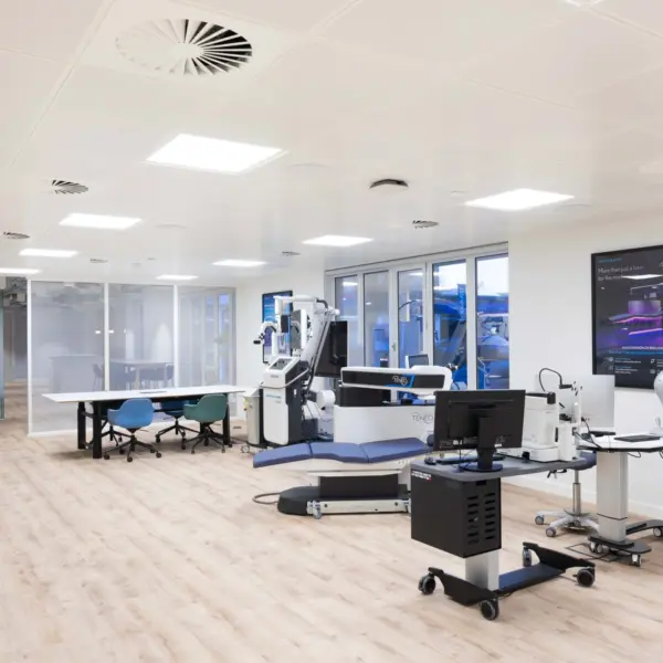 Modern office fit out featuring an open plan training and technical workspace with adjustable desks, integrated technology benches, glass partitioned rooms, timber flooring and a bright contemporary office design