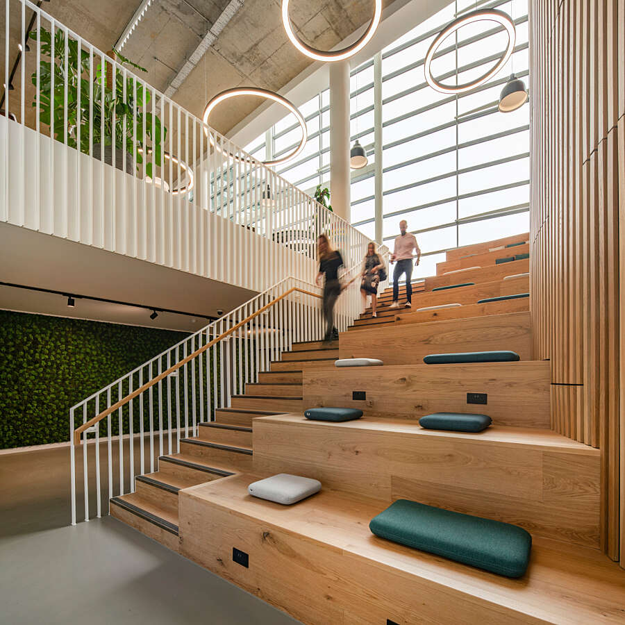 Bespoke oak lecture style seating runs parallel to stairs
