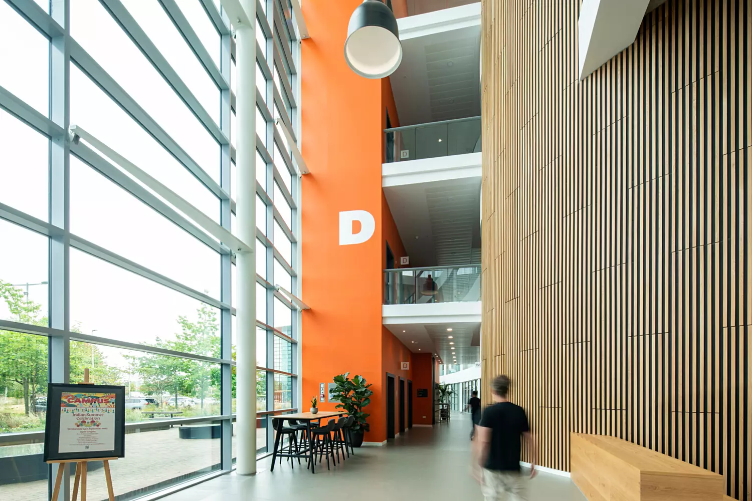 Bespoke timber beading softens the space next to the bright wayfinding colours associated with Campus brand