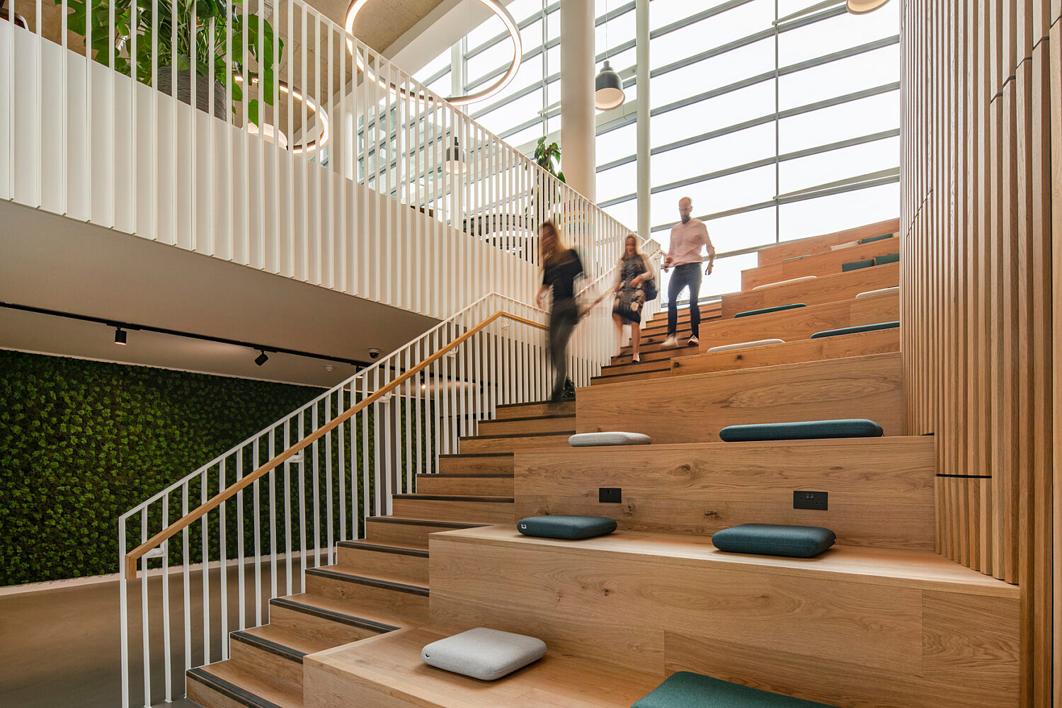 Bespoke oak lecture style seating runs parallel to stairs