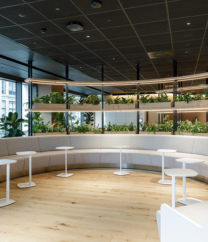 Round bench seating in front of shelves of plants