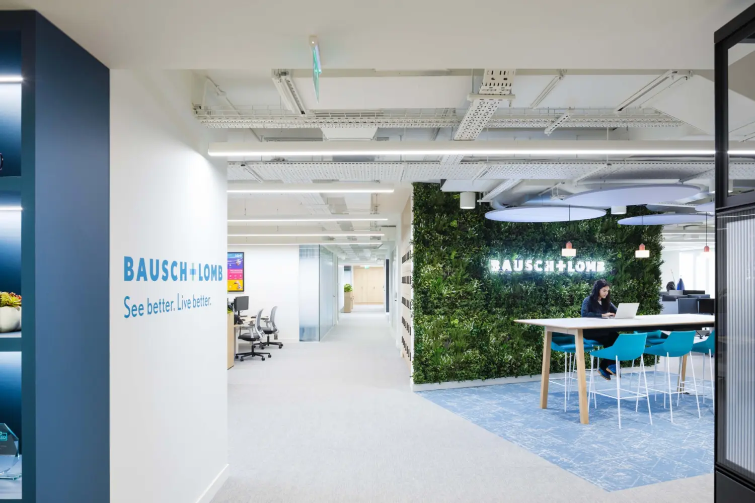 Modern office fit out featuring biophilic office design with a living green wall, open plan workspace, branded reception area and contemporary breakout seating