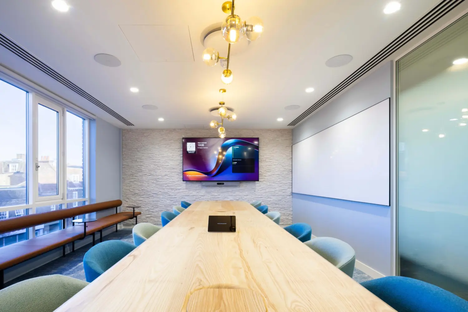 Modern office fit out featuring a contemporary boardroom with large meeting table, integrated video conferencing screen, glazed partition walls, pendant lighting and a refined corporate office design